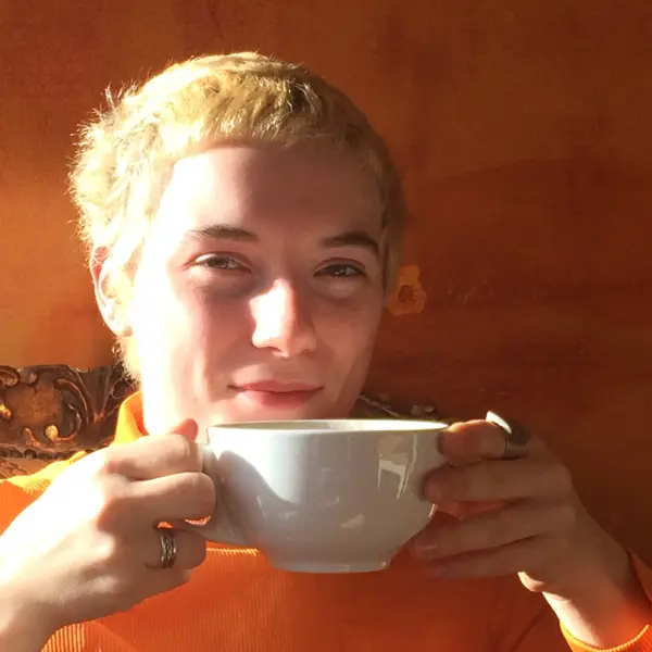 Evie In Orange & Drinking Coffee